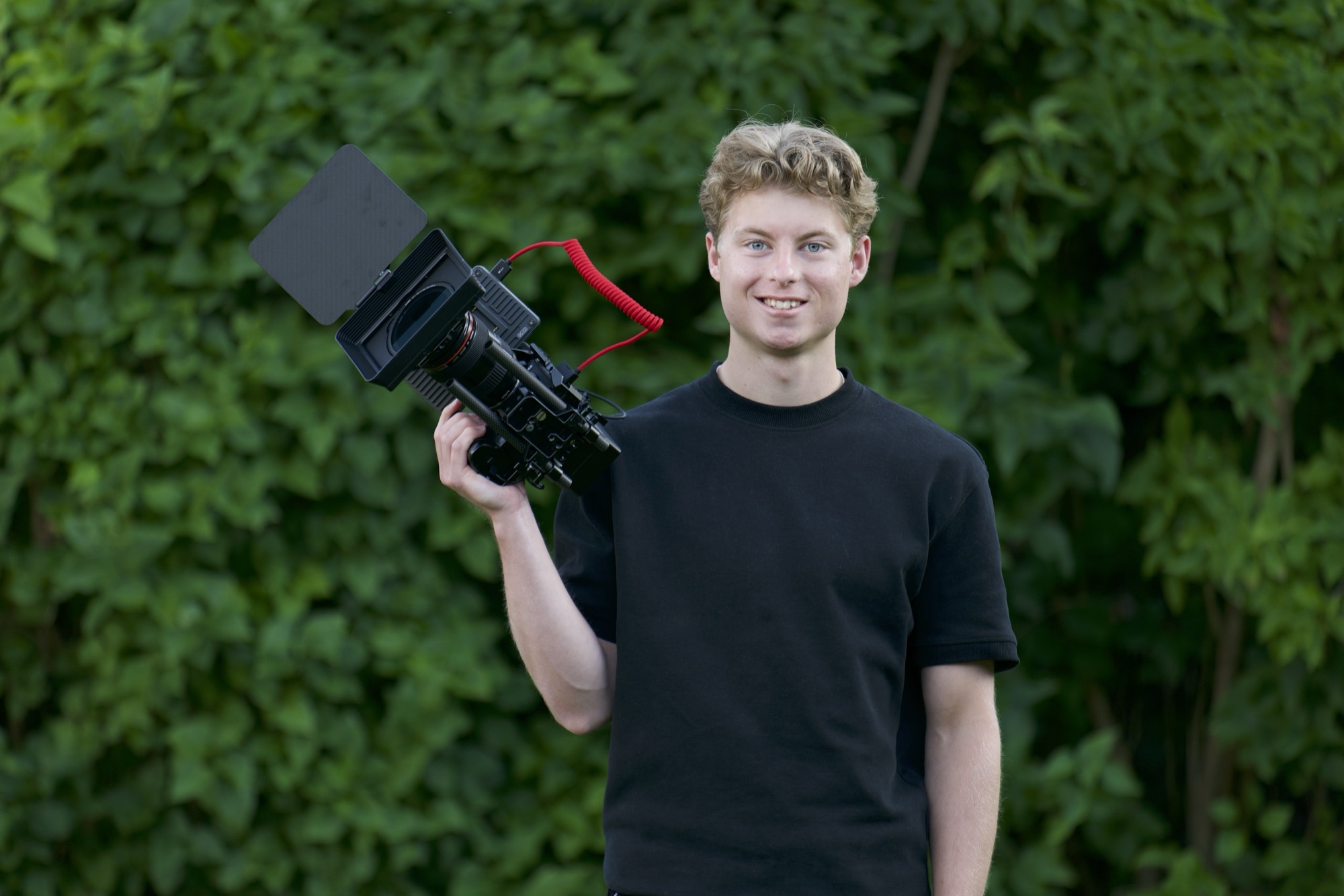 Videografen bakom Bäck Film med kameran på axeln